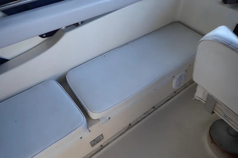 Slide: The Image of 1988 Mainship boat interior with white cushioned seating and speaker. - 39