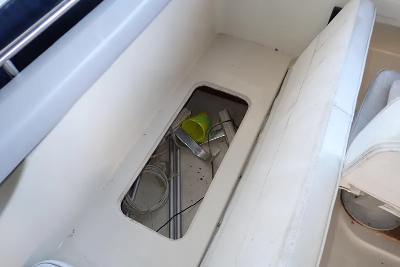 Slide: The Image of 1988 Mainship boat interior storage compartment with cables and a yellow cup. - 40