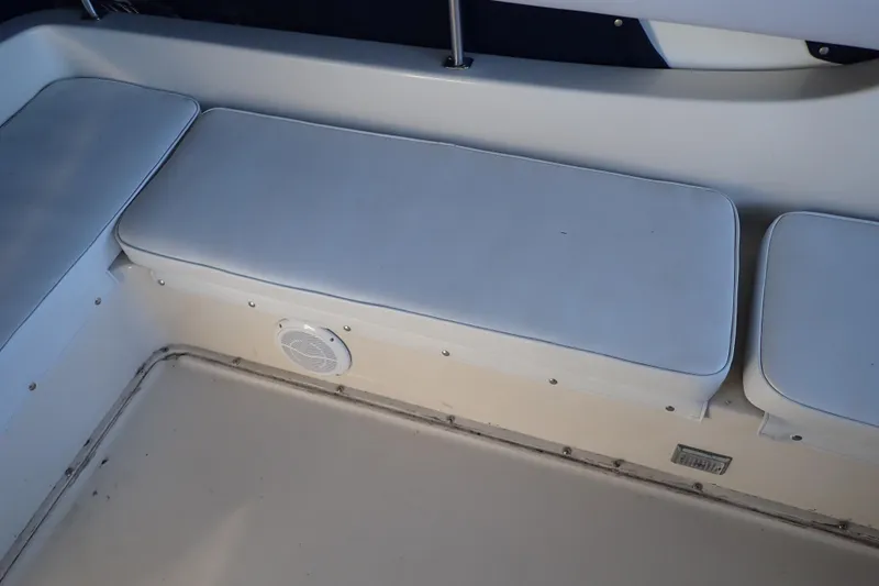 Slide: The Image of 1988 Mainship boat interior with white cushioned seating and speaker. - 41