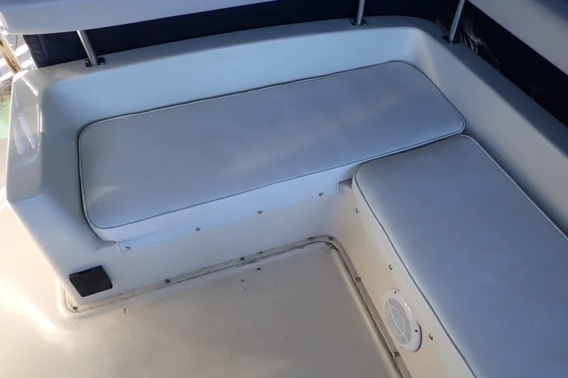 Slide: The Image of 1988 Mainship boat interior with white cushioned seating and speaker. - 43