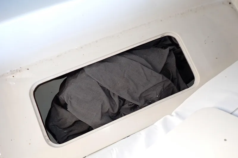 Slide: The Image of Storage compartment on a 1988 Mainship boat with black fabric inside. - 45