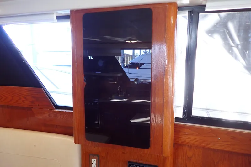 Slide: The Image of 1988 Mainship interior with wooden paneling and window, showcasing classic yacht design. - 50