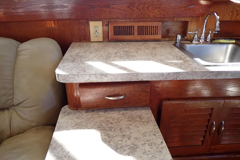 Slide: The Image of 1988 Mainship boat interior with countertop, sink, and wooden cabinetry. - 57