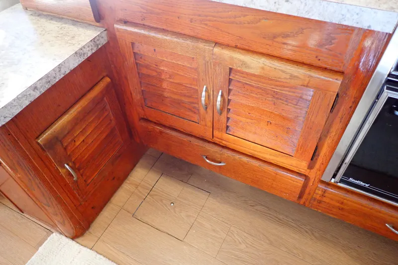 Slide: The Image of 1988 Mainship wooden kitchen cabinets with louvered doors and marble countertop. - 59