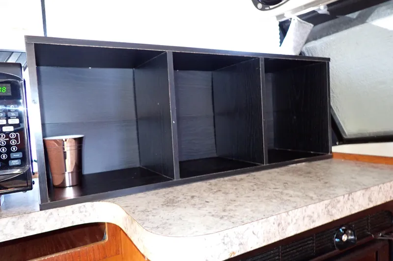 Slide: The Image of 1988 Mainship interior with countertop, microwave, and storage shelves. - 64