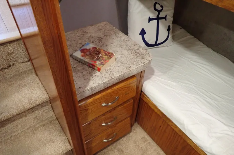 Slide: The Image of 1988 Mainship cabin interior with anchor pillow, book, and wooden drawers. - 77