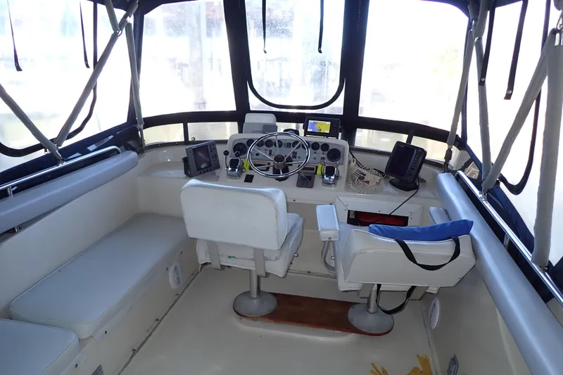 Slide: The Image of 1988 Mainship boat cockpit with steering wheel, navigation equipment, and seating. - 8