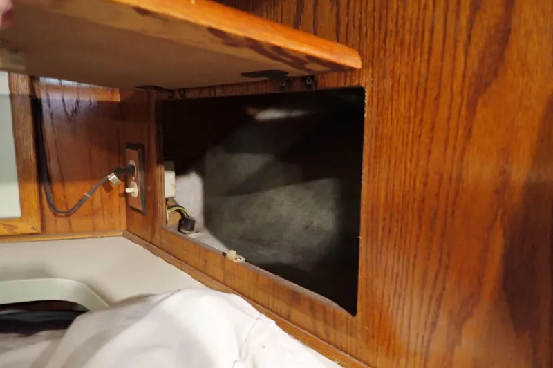 Slide: The Image of 1988 Mainship interior with open wooden cabinet and visible electrical outlet. - 82