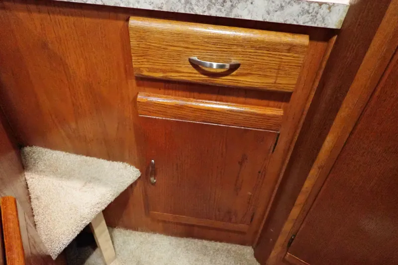 Slide: The Image of 1988 Mainship interior with wooden cabinetry and carpeted step. - 87