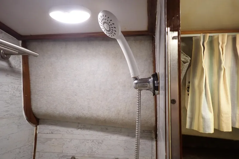Slide: The Image of Shower area in a 1988 Mainship boat with curtain and showerhead. - 99