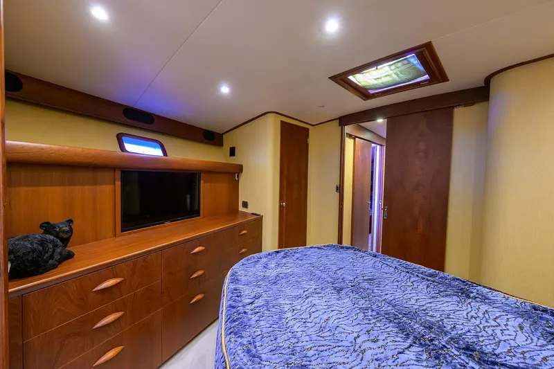 Slide: The Image of 1987 Merritt Boat Works Sport Fisherman cabin with wood cabinetry and plush bedding. - 41