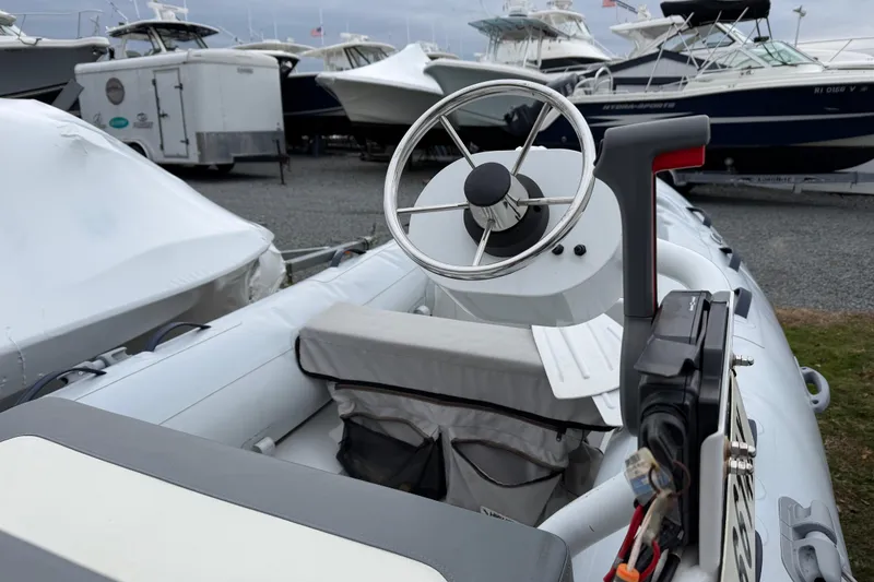 Slide: The Image of 2019 Highfield Classic 380 boat interior with steering wheel, docked among other boats. - 13