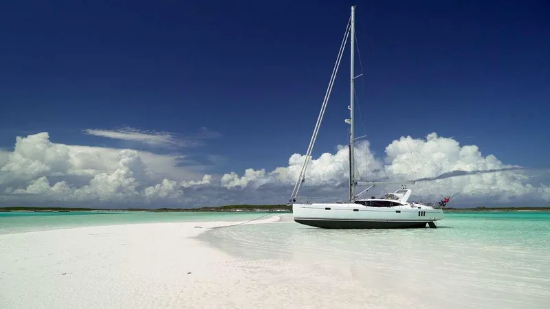 Slide: The Image of Sailboat Southerly 480 (2025) anchored on pristine tropical beach with clear blue skies. - 30