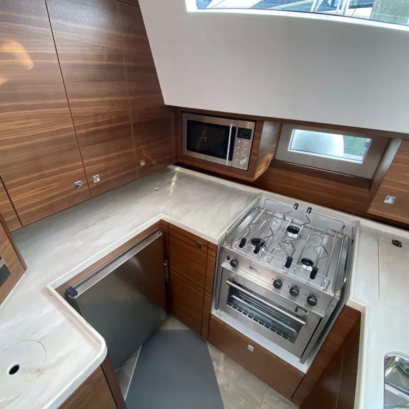 Slide: The Image of Modern kitchen in a 2025 Southerly 480 yacht with wood cabinetry and stainless steel appliances. - 40