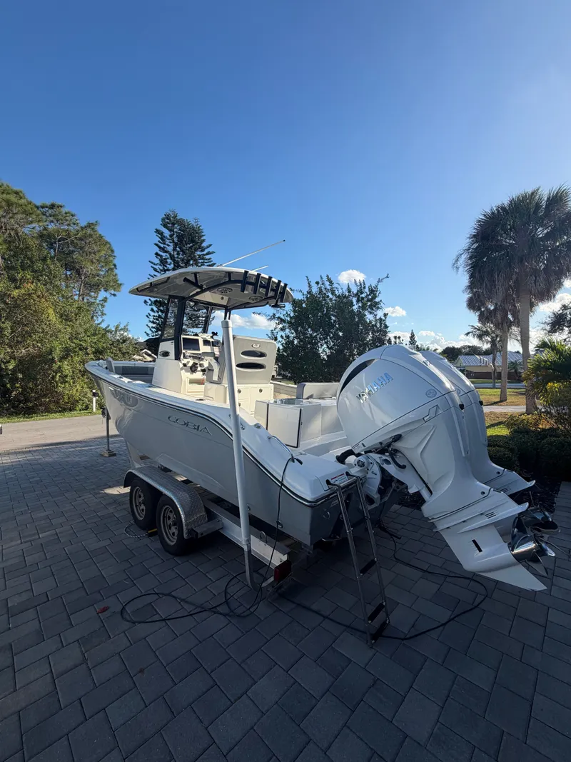 The Image of 2024 Cobia 240 Center Console boat on trailer, sunny day. - 0