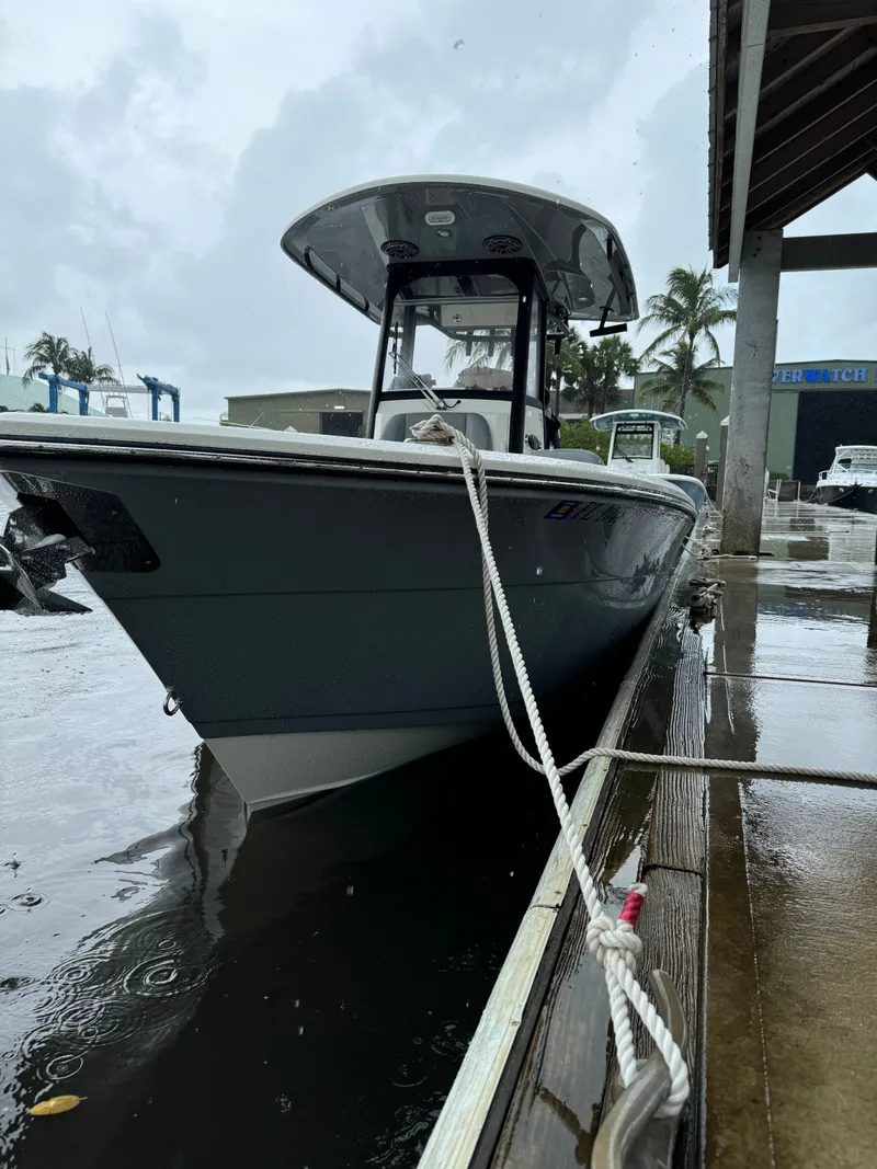 Slide: The Image of 2024 Cobia 240 Center Console boat docked in rainy weather. - 22