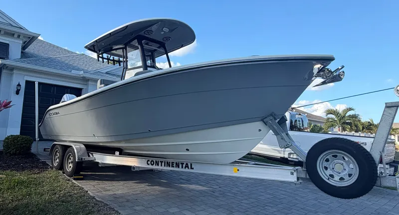 Slide: The Image of 2024 Cobia 240 Center Console on trailer in front of house. - 3