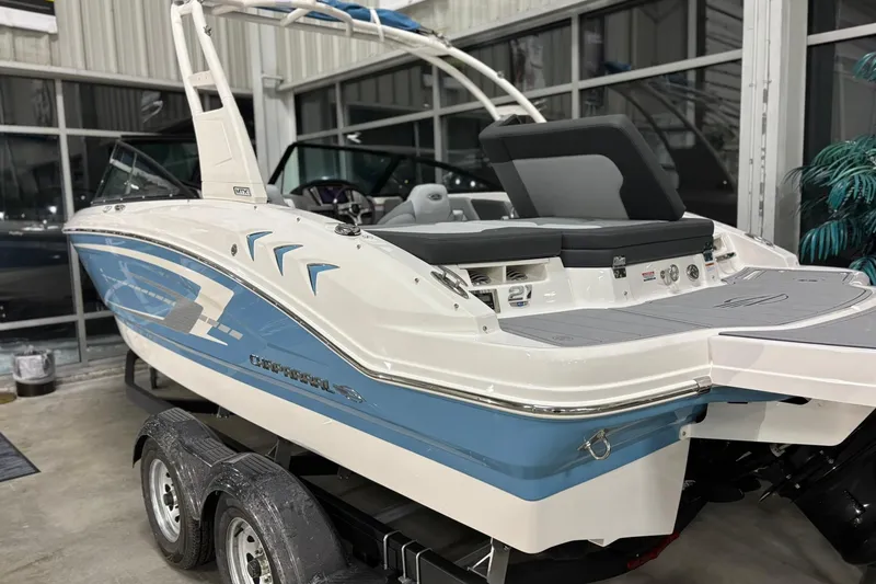 Slide: The Image of 2026 Chaparral 21 SSi boat on trailer, displayed indoors with sleek design. - 26