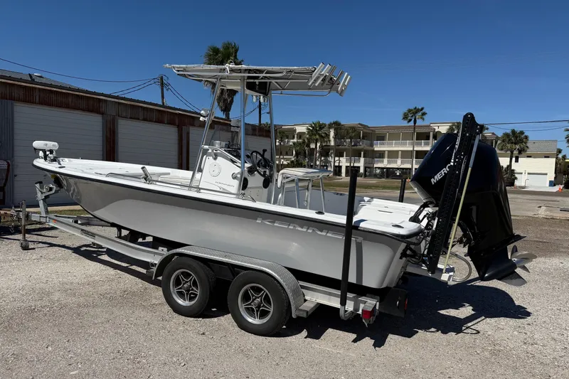 Slide: The Image of 2003 Kenner 21 V Tunnel boat on trailer, parked outdoors under clear blue sky. - 2