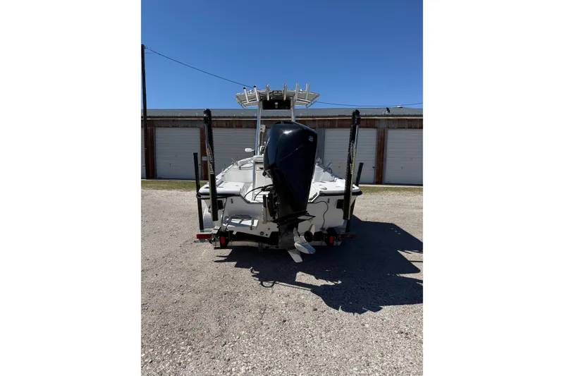 Slide: The Image of 2003 Kenner 21 V Tunnel boat, rear view with outboard motor, parked outdoors. - 3