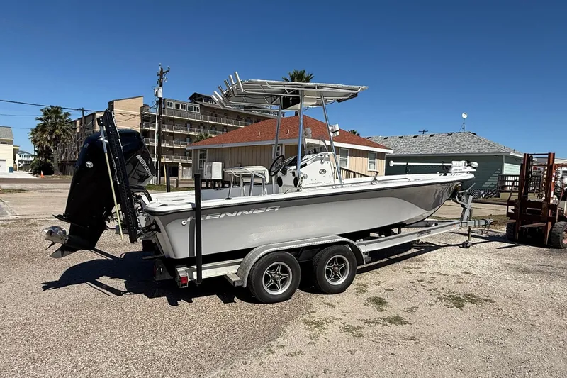 Slide: The Image of 2003 Kenner 21 V Tunnel boat on trailer, parked outdoors under clear blue sky. - 4