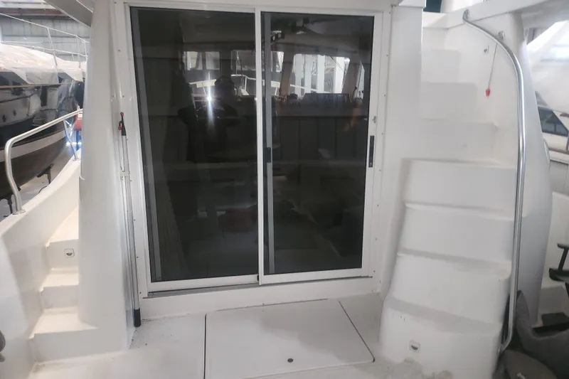 Slide: The Image of 1997 Mainship 350 Trawler with sliding glass doors and exterior stairs in a marina setting. - 15