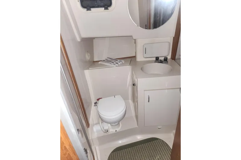 Slide: The Image of 1997 Mainship 350 Trawler bathroom with toilet, sink, and storage cabinet. - 17