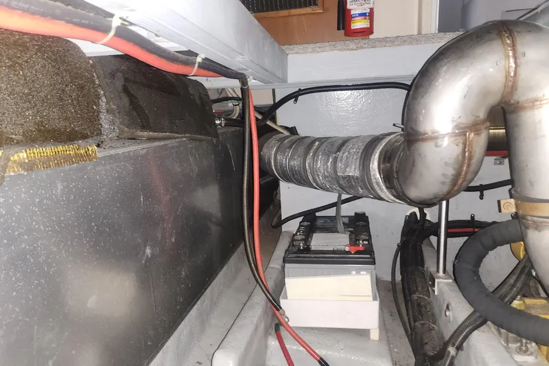 Slide: The Image of Engine room of a 1997 Mainship 350 Trawler with visible battery and exhaust system. - 18