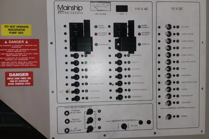 Slide: The Image of Electrical panel of a 1997 Mainship 350 Trawler with safety warnings and controls. - 20