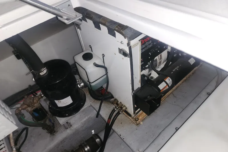 Slide: The Image of Engine compartment of a 1997 Mainship 350 Trawler, showing mechanical components and wiring. - 21