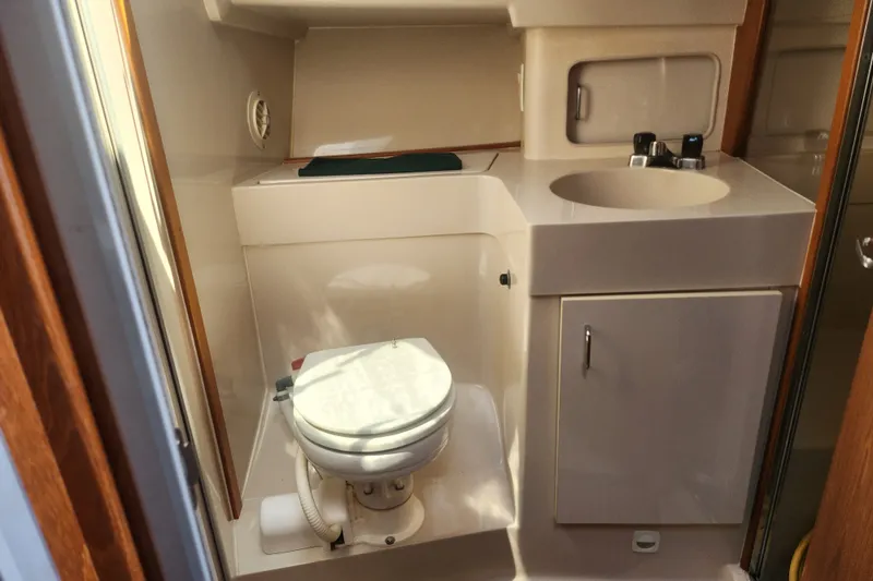 Slide: The Image of Bathroom interior of a 1997 Mainship 350 Trawler, featuring a toilet and sink. - 21