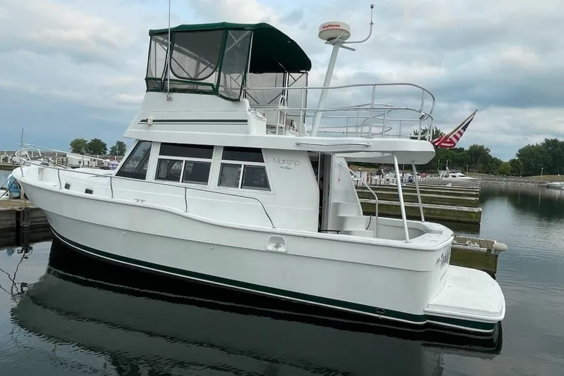 Slide: The Image of 1997 Mainship 350 Trawler docked at a marina, featuring a spacious upper deck. - 3