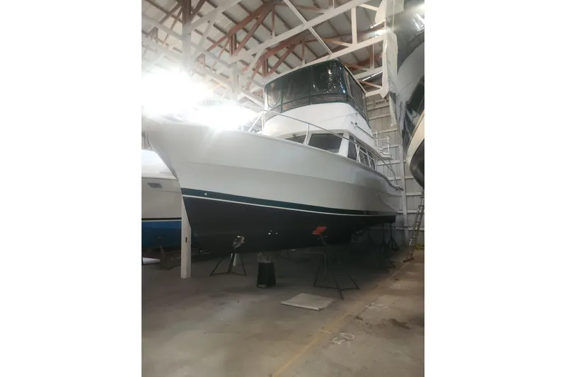 Slide: The Image of 1997 Mainship 350 Trawler in a boatyard, showcasing its sleek design and sturdy build. - 3