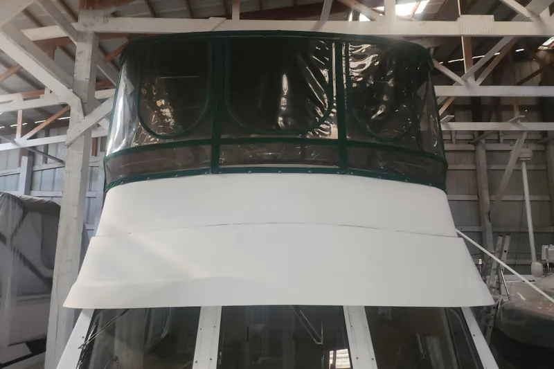 Slide: The Image of 1997 Mainship 350 Trawler in storage, featuring enclosed flybridge and white exterior. - 4