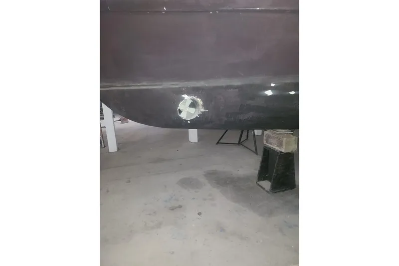 Slide: The Image of 1997 Mainship 350 Trawler hull in dry dock, showing repair work. - 9