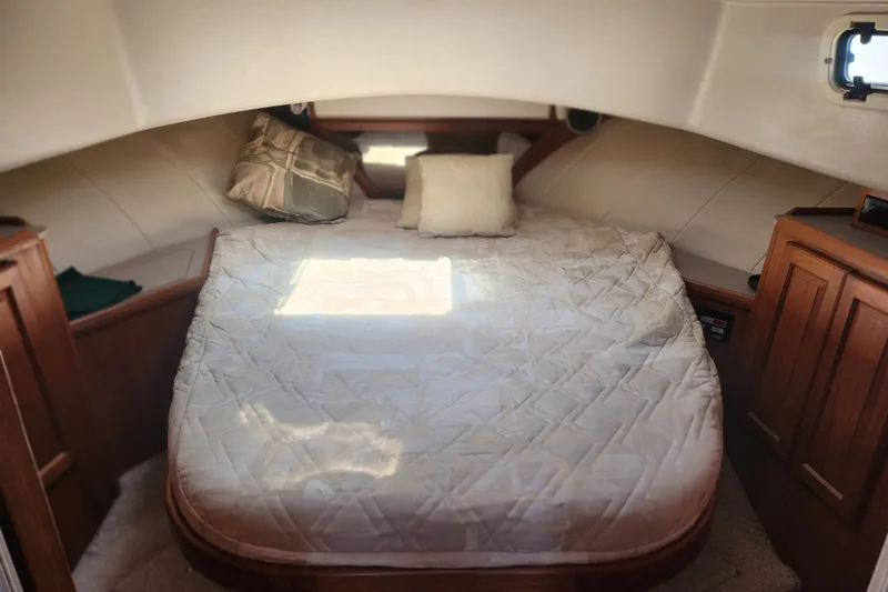 Slide: The Image of Cozy cabin interior of 1997 Mainship 350 Trawler with bed and wooden cabinets. - 16