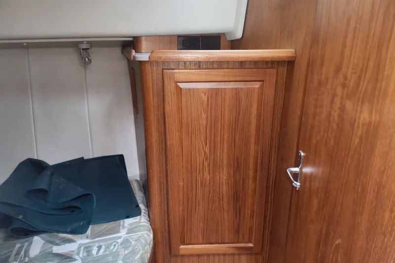 Slide: The Image of Wooden interior of a 1997 Mainship 350 Trawler, featuring cabinetry and seating area. - 19