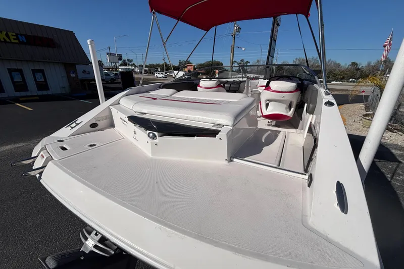 Slide: The Image of 2008 Regal 2000 Bowrider boat with red canopy, parked outdoors. - 10