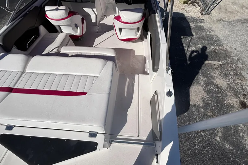 Slide: The Image of 2008 Regal 2000 Bowrider interior with white and red seating, shadow on pavement. - 15