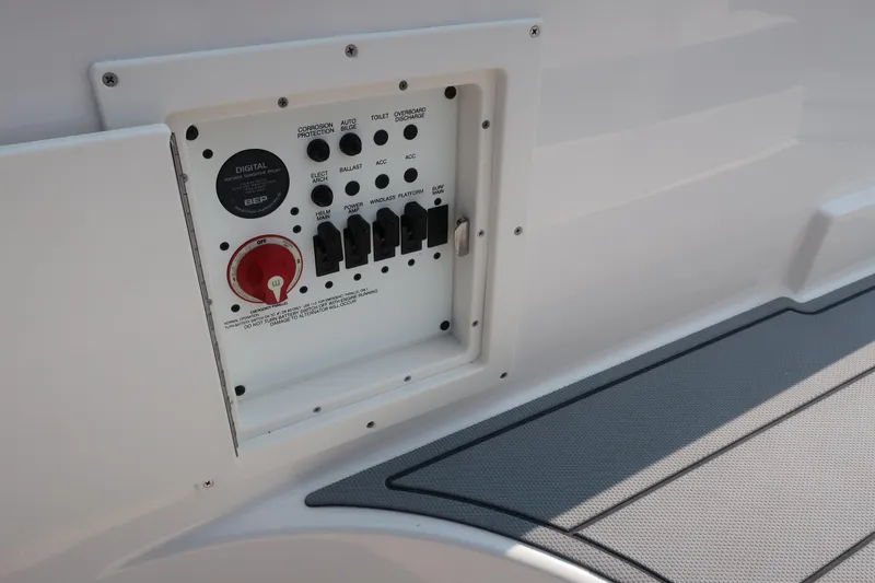 Slide: The Image of Control panel on 2021 Chaparral 267 SSX boat, featuring switches and a red dial. - 13