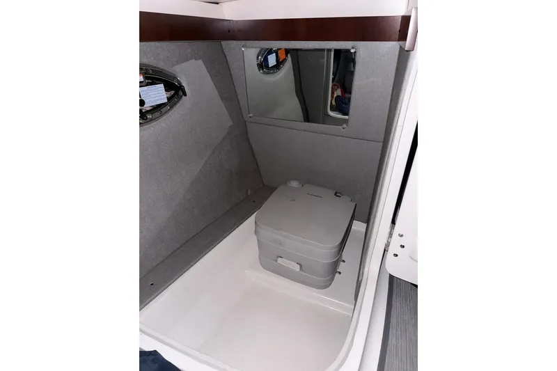 Slide: The Image of 2021 Chaparral 267 SSX boat interior with portable toilet and mirror. - 23