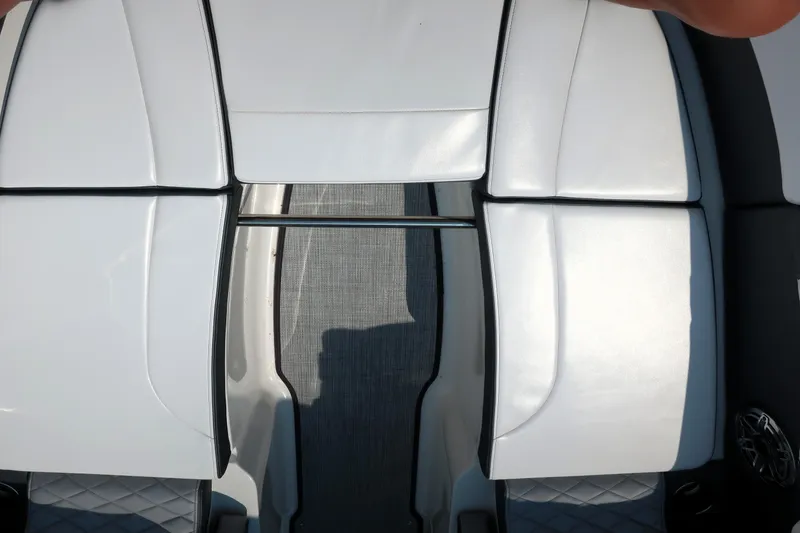 Slide: The Image of 2021 Chaparral 267 SSX boat interior with white cushioned seating and sleek design. - 6