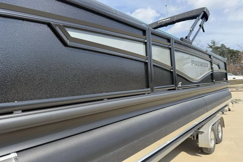 Slide: The Image of 2026 Premier 230 Intrigue RF pontoon boat, sleek black design on a trailer. - 4
