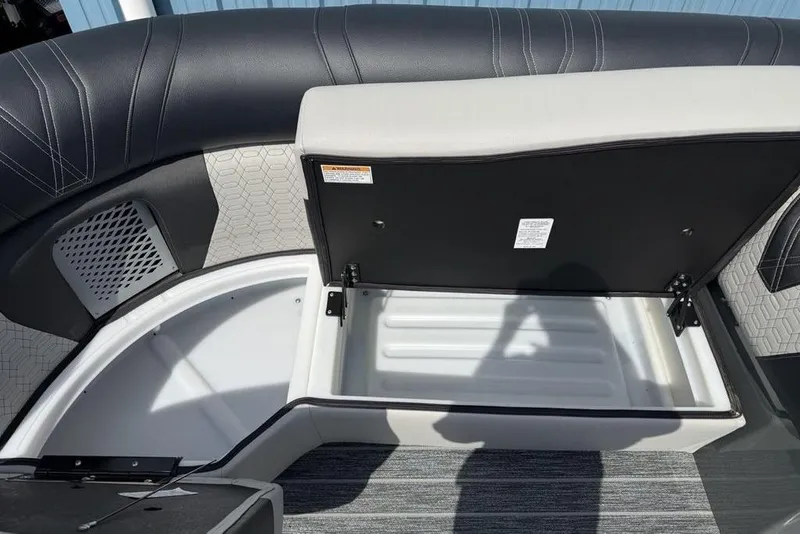 Slide: The Image of 2026 Premier 230 Intrigue RF boat interior with open storage compartment and cushioned seating. - 7