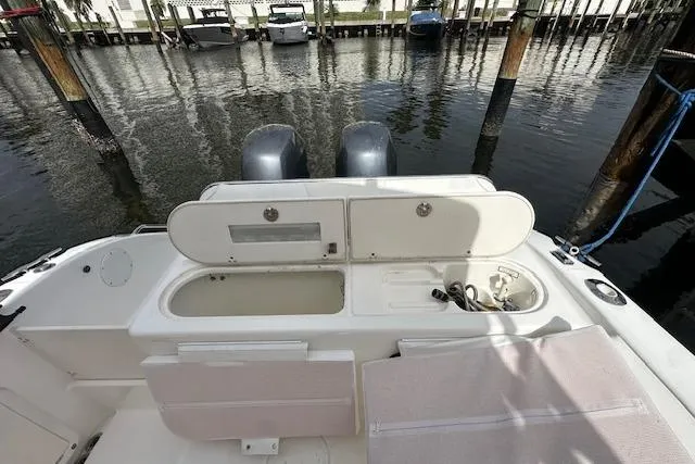 Slide: The Image of 2005 Century 2600 Walk-Around boat with open storage compartments, docked at marina. - 10