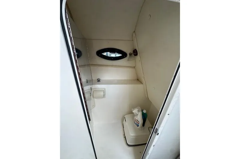 Slide: The Image of 2005 Century 2600 Walk-Around boat cabin interior with compact toilet and cleaning supplies. - 15