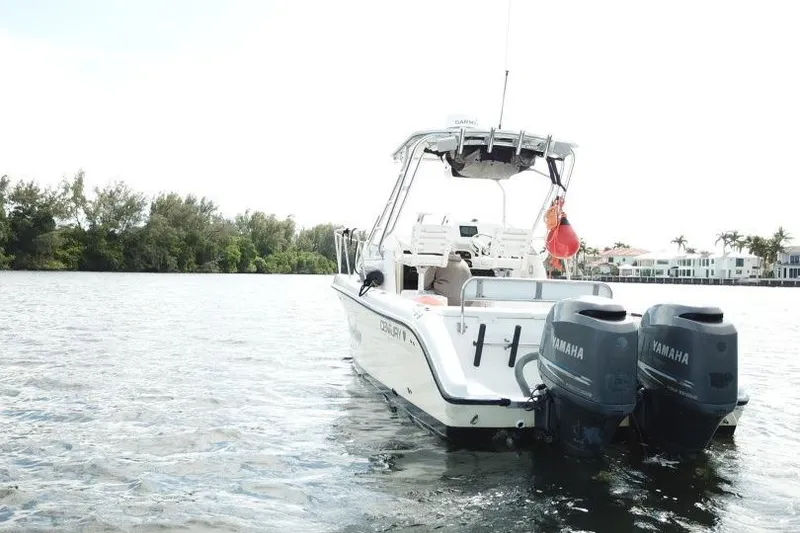 Slide: The Image of 2005 Century 2600 Walk-Around boat with twin Yamaha engines on a calm waterway. - 18