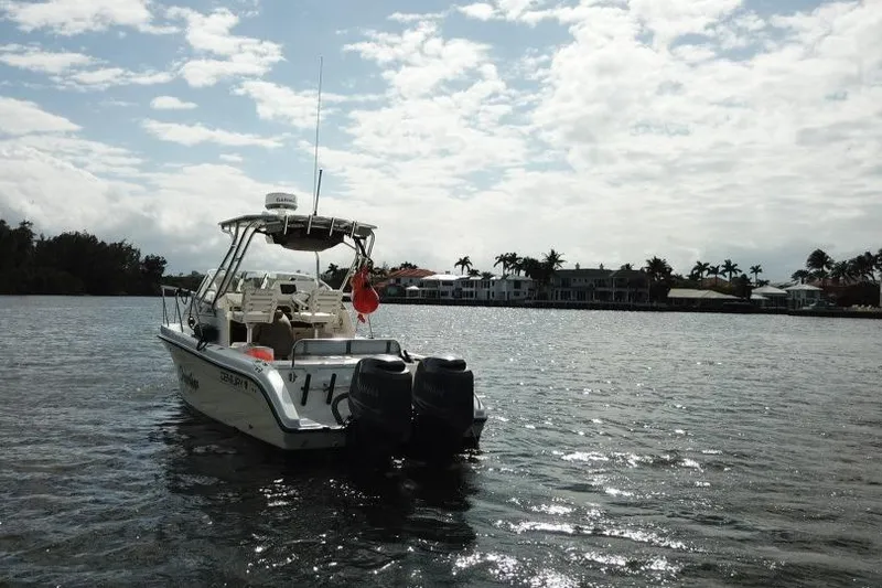 Slide: The Image of 2005 Century 2600 Walk-Around boat on water, with coastal homes in the background. - 19