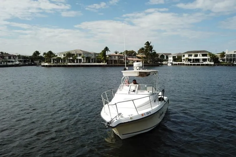 Slide: The Image of 2005 Century 2600 Walk-Around boat on a calm waterway with waterfront homes. - 5