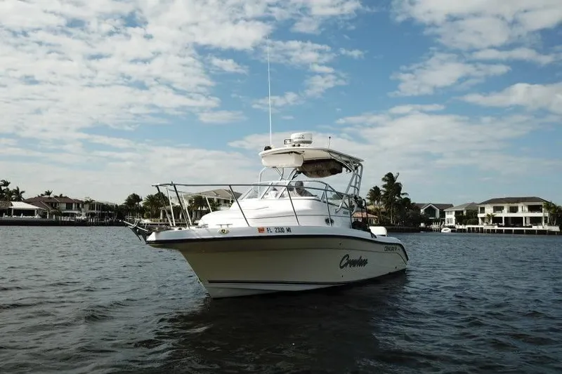 Slide: The Image of 2005 Century 2600 Walk-Around boat on water, with coastal homes in the background. - 6